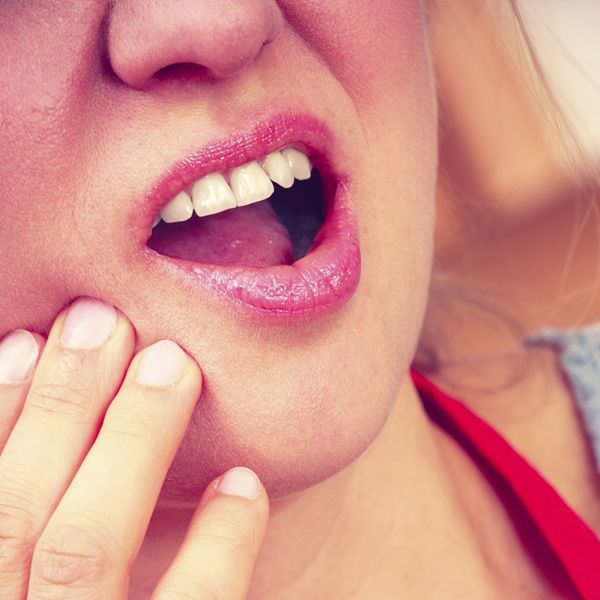 Woman holding mouth in pain